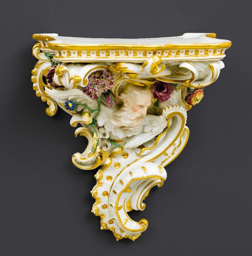 RARE WALL CONSOLE, Meissen, circa 1763-1774.Model probably by J.J. Kaendler. Wedge-shaped, modeled with rocailles and applied with flowers and leaves as well as the head of Chronos as allegory of time. 28.5 x 25 x 18cm. Small, typical chips on flowers and leaves.