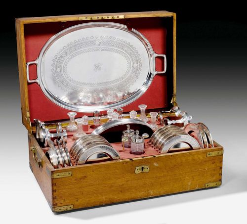 TRAVEL SET, St. Petersburg 1873.Assay master's mark: I.E. Maker's mark: Sasikow. Comprising: oval two-handled tray, 12 plates with D 15.5 cm, 6 plates with D 18.2 cm, 1 two-handled bowl, 2 cruet sets with glass carafes for oil, vinegar, salt and mustard with spoons. All in matching leather case. Total weight: 9940 g. Closing mechanism of one carafe damaged. Provenance: de Uthemann Collection.
