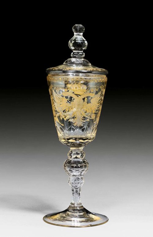GLASS GOBLET AND COVER FOR EMPRESS ELIZABETH PETROVNA, St. Petersburg, circa 1741-1762,or Saxony, mid-18th century. With gold-heightened, deep cut crowned monogram of Empress Elizabeth Petrovna (1741-1762) flanked by arms trophies and rocaille borders, and with crowned double eagle with scepter and orb on the opposite side. H 32.5 cm. Minor chip to the foot edge.