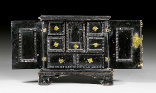MINIATURE CABINET,early Baroque, probably German or Dutch, 17th/18th century. Ebonized wood, with fine ornamental wave frieze. The fitted interior with large central drawer above 2 adjacent drawers and flanked on each side by 2 small drawers. Brass mounts and knobs. 19x15x20 cm.