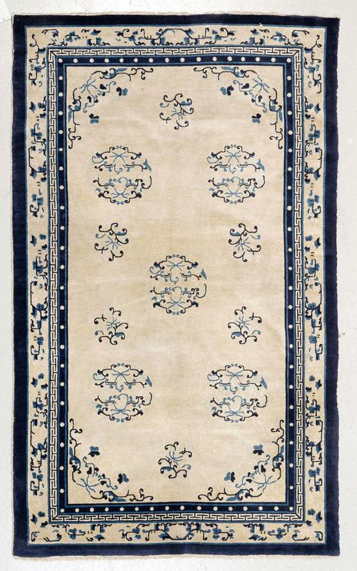CHINA old.Beige ground, patterned with round medallions with tendril motifs, beige and blue border, slightly stained, 135x230 cm.