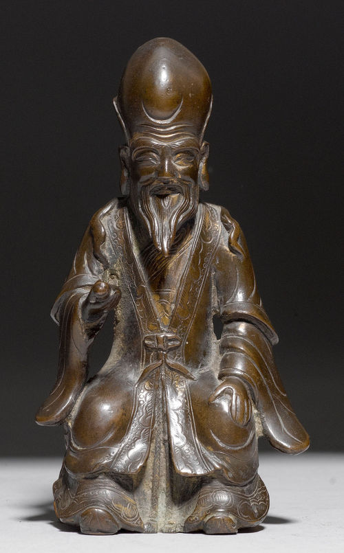 A BRONZE FIGURE OF SHOULAO SEATED ON A WOODEN BASE.