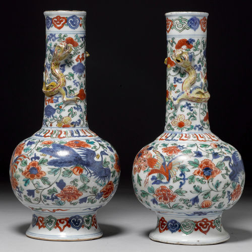 A PAIR OF FOOTED WUCAI VASES IN THE WANLI STYLE WITH PHOENIXES AND CHILONGS IN RELIEF ON A FLORAL GROUND.