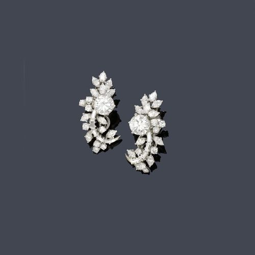 DIAMOND EAR CLIPS, ca. 1950. Platinum ca. 680, clip in white gold 750. Classic-elegant ear clips designed as a stylized leaf, each set with 1 brilliant-cut diamond, total weight ca. 3.00 ct, ca. F/VVS1 and F/ SI1, respectively, and each additionally decorated with  5 baguette-cut diamonds, 10 navette-cut diamonds and 8 brilliant-cut diamonds, total diamond weight ca. 2.50 ct With case. Tested by Gemlab.