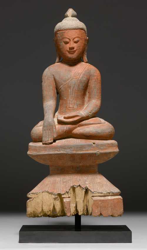 A WOODEN FIGURE OF A SEATED BUDDHA, ITS HAND IN THE EARTH-TOUCHING MUDRA.