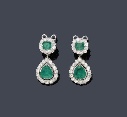 EMERALD AND DIAMOND EAR PENDANTS, ca. 1935. Platinum, mechanical part of the clip in white gold. Elegant, very decorative ear clips with studs, each of one pendant set with 1 drop-cut Columbian emerald, weighing ca. 5.50 ct in total, within a border of 16 diamonds weighing ca. 2.40 ct in total, flexibly mounted below a rosette motif set with 1  step-cut rosette motif set with 1 step-cut emerald, weighing ca. 2.90 ct in total, within a border of diamonds, weighing ca. 1.20 ct in total. L ca. 3.5 cm. With case and SSF Report No. 58104, December 2010.