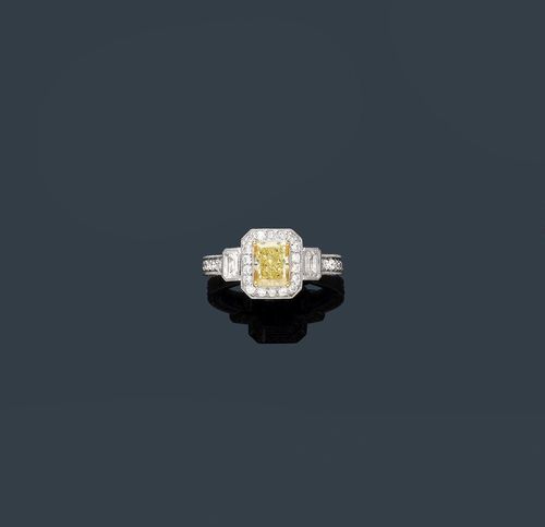 FANCY DIAMOND RING. Platinum 950 and white gold 750. Decorative, elegant ring, the top set with 1 radiant-cut diamond of ca. 1.30 ct, Light Fancy Yellow, flanked by 2 octagonal diamonds weighing ca. 0.40. The setting and the ring shoulders set throughout with numerous brilliant-cut diamonds weighing ca. 0.96 ct in total. Size ca. 55. With shop certificate, October 2012.
