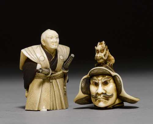 TWO CARVED IVORY NETSUKE, ONE WEARING A HELMET ADORNED WITH GOLD APPLIQUÉS, THE OTHER A FIGURE OF OKUBO HIKOZAEMON.