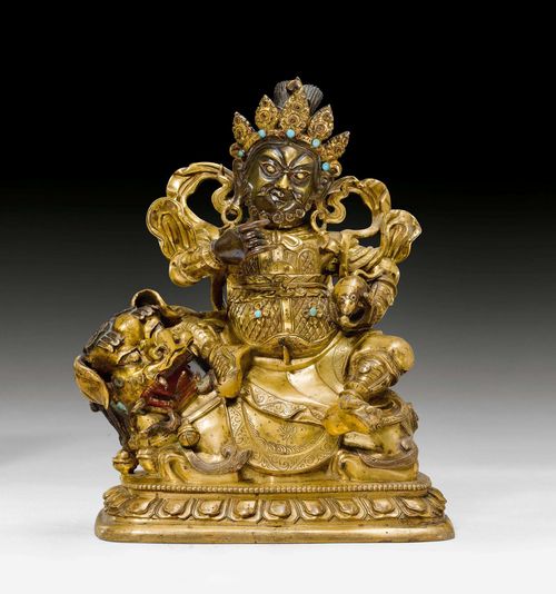 A GILT BRONZE FIGURE OF VAISHRAVANA ON HIS LION. Tibeto-chinese, 18th c. Height 17 cm. Unsealed. Turquoise inlays added.