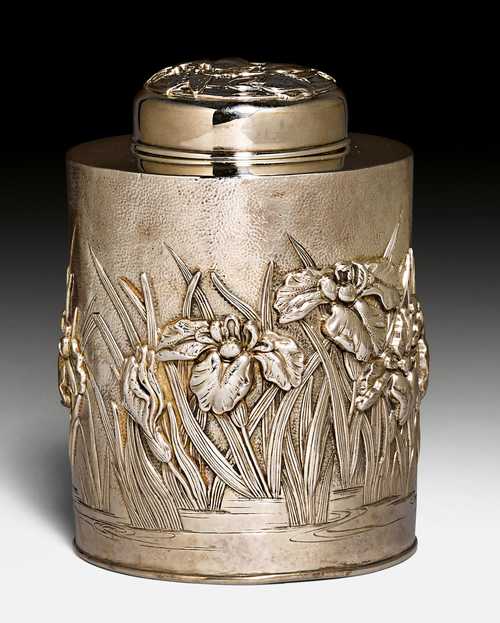 A SILVER TEA CADDY WITH REPOUSSE IRIS DECORATION.