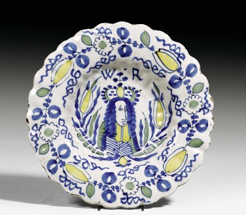 FAN PLATE 'PLOOISCHOTEL WILLEM II', DELFT, CIRCA 1690.Painted in blue and yellow with 'Koning Stadhouder Willem II Prins von Oranije' with monogram WR in the center and stylized floral decoration on the edge. D 31cm. Hairline crack.