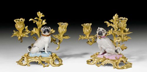 PAIR OF GILT BRONZE CANDELABRAS WITH SITTING PUGS, THE PORCELAIN MEISSEN, CIRCA 1745.The gilt bronze mount in Louis XV style, France, probably late 18th century. Applied with porcelain flowers, Paris, 19th century. H 18 cm. Chips and repairs.