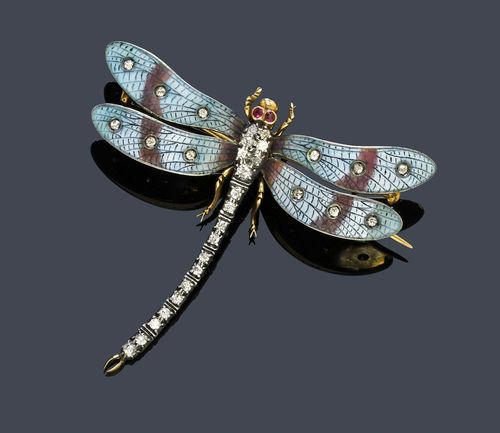 ENAMEL, DIAMOND AND RUBY BROOCH, ca. 1900. Silver over yellow gold. Decorative brooch designed as a dragonfly, the body set throughout with 19 old European-cut diamonds weighing ca. 0.40 ct, the wings finely decorated with translucent blue-brown enamel and decorated with 12 diamonds weighing ca. 0.20 ct. With 2 small rubies as eyes. Removable mechanical part. Ca. 6.5 x 6 cm. With original case signed W. Batty & Sohn, Market St. Manchester.