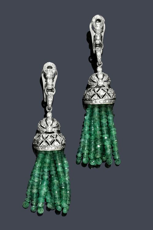 EMERALD  AND DIAMOND EAR PENDANTS. White gold 750. Decorative ear clips with hinged studs, in the Art Deco style. The lower part, each of a flexibly mounted pendant set with brilliant-cut diamonds, with a tassel of emerald rondelles weighing 32.00 ct. Total diamond weight ca.1.32 ct. L ca. 7.8 cm.