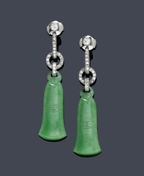 JADEITE AND DIAMOND EAR PENDANTS, ca. 1925. Platinum. Decorative ear pendants with studs, each of 1 engraved bell-shaped jadeite, flexibly mounted on a diamond-set ring motif between 2 diamond-set, elongated eyelets. Numbered 15555. Total weight ca. 0.70 ct. Stud mechanism, not original. L ca. 5.5 cm.
