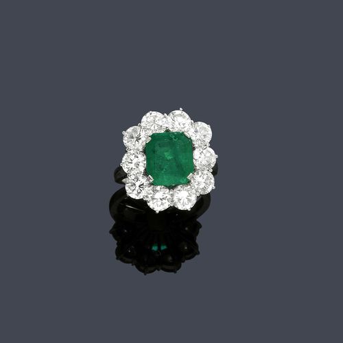 EMERALD AND DIAMOND RING, ca. 1950. Platinum. Classic-elegant ring, the top set with 1 step-cut emerald of ca. 2.50 ct, within a border of 12 brilliant-cut diamonds weighing ca. 3.50 ct. Size ca. 52.