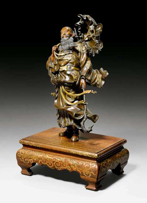 A VERY LIVELY BRONZE FIGURE OF A SAGE STRUGGLING AGAINST THE WIND. Japan, Meiji period, height 49.5 cm (without base). Signed: Miyao z&#244;. Wood base with gilt lacquer decoration.