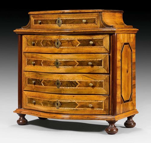 MODEL CHEST OF DRAWERS,Baroque, South German circa 1750. Walnut and fruit woods inlaid with reserves and decorative frieze. The front with 5 drawers, the top drawer slightly smaller. Brass knobs and escutcheons. 47x27x48 cm.