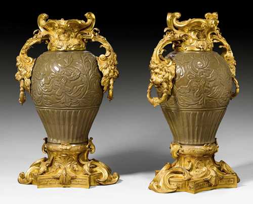 PAIR OF IMPORTANT VASES WITH BRONZE MOUNTS "AUX TETES DE LIONS",late Regence/Louis XV, the porcelain from a European factory in "imitation de Celadon" of the Yuan period (1279-1368), the bronze from a Paris master workshop circa 1750. Fine, relief-decorated porcelain, painted in celadon style, with matte and polished gilt bronze. H 75 cm. Provenance: - In all likelihood, acquired by Edward Levy-Lawson, 1st Baron Burnham (1833-1913) for his Hall Barn estate in Beaconsfield, Buckinghamshire. - Harry Levy-Lawson, 2nd Baron Burnham (1862-1933). - William Lawson, 3rd Baron Burnham (1864-1943). - Edward Frederick Lawson, 4th Baron Burnham (1890-1963). - William Lawson, 5th Baron Burnham (1920-1993). - Christie's London auction on 22.9.1969 (Lot No. 96). - Christie's London auction on 11.6.1993 (Lot No. 8). - From a highly important European private collection.