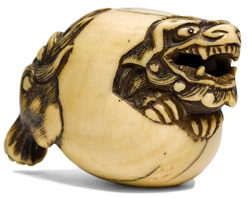 A NETSUKE OF A LION BREAKING FREE FROM AN EGG SHELL.