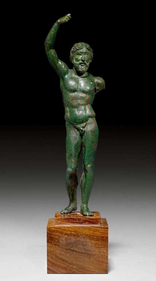 BRONZE FIGURE OF ZEUS,Greece, 5th century BC. Bronze with green patina. Zeus standing with his right arm raised, on a stepped, square wooden base. H 18 cm (without base). H 23.5 cm (with base). Provenance: - Former private collection, Zurich. - Auction Sotheby's New York, 17.12.1998 (Lot No. 113). - Galerie D. Cahn, Basel. - Private collection, Switzerland. Exhibition: Gallery André Emmerich, New York, 7.2.1968-13.3.1968.