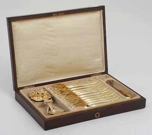 LOT COMPRISING 12 SILVER-GILT TEA SPOONS WITH SUGAR TONGS, AND A TEA STRAINER AND  LADLE IN  A WOODEN CASE