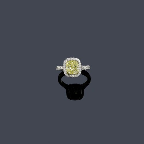 FANCY YELLOW DIAMOND RING. White gold 750. Decorative, elegant ring, the top set with 1 fancy-yellow cushion-cut diamond of 3.03 ct, IF, within a border of brilliant-cut diamonds weighing ca. 0.20 ct in total. The ring shoulders and the setting are additionally decorated with 34 brilliant-cut diamonds weighing ca. 0.40 ct in total. Size ca. 52. With GIA Report No. 2145743170, August 2012.