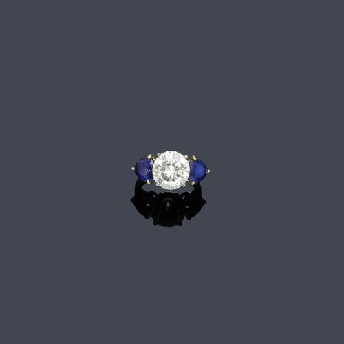 DIAMOND AND SAPPHIRE RING, ca. 1960. Platinum 900 and yellow gold 750. Elegant ring, the top set with 1 brilliant-cut diamond weighing 5.01 ct, M-R/VS1, flanked by 2 heart-shaped  sapphires weighing ca. 3.00 ct in total. Size ca. 49. With case and SSEF Report No. 67825, April 2013.