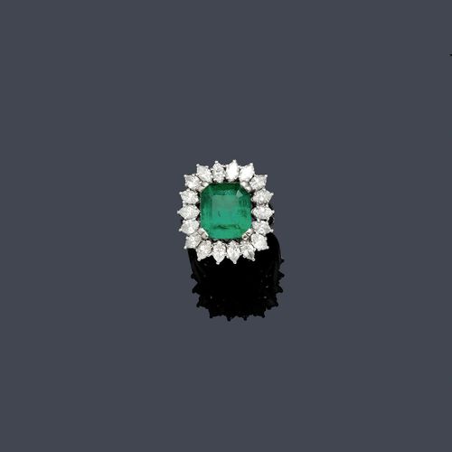EMERALD AND DIAMOND RING, ca. 1950. White gold 750. Classic-elegant ring, the top set with 1 fine, step-cut Columbian emerald weighing ca. 6.00 ct, slightly oiled, within a border of 18 navette-cut diamonds weighing ca. 1.60 ct. Size ca. 53. With case. Oral estimate by GGTL/ Gemlab.