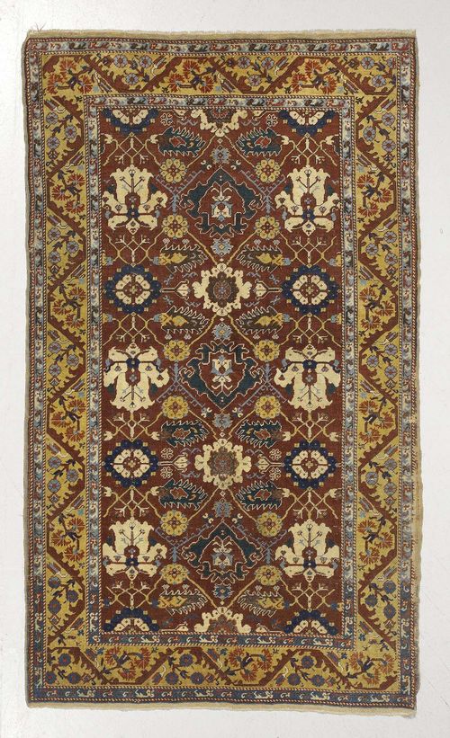 TURKISH antique.Rust coloured central field patterned throughout with stylized blossoms, yellow border with trailing flowers, strong signs of wear, 152x240 cm.