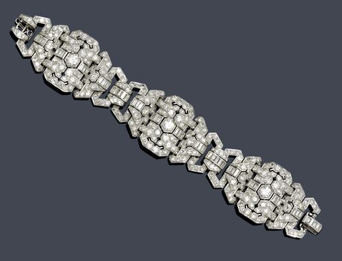 DIAMOND BRACELET, ca. 1930. Platinum. Very elegant bracelet , the geometrically open-worked links set with 3 old European-cut diamonds weighing ca. 2.30 ct in total, 51 baguette-cut diamonds weighing ca. 4.00 ct in total, and set throughout with ca. 260 brilliant-cut diamonds weighing ca. 14.00 ct in total. W ca. 3 cm, L ca. 18.5 cm. With leather pouch by René Kern.