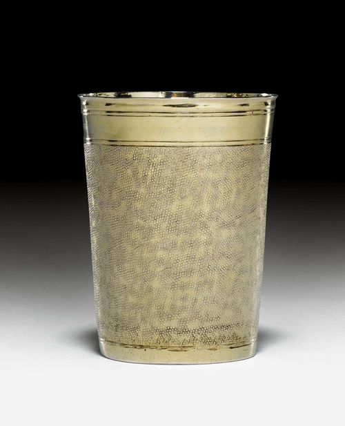 SILVER-GILT SNAKESKIN BEAKER,Nuremberg 1665-69. Maker's mark Johann Höfler. Slightly conical form with profiled rim. Wall embossed all around, smooth lip and foot. Retracted bottom. Gilding probably not original. H 8.8 cm, 130g. Provenance: German private collection.