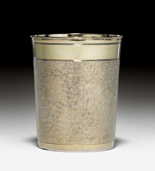 SILVER-GILT SNAKESKIN BEAKER,Augsburg ca. 1680-84. Maker's mark Johann Wagner. Slightly conical form with profiled rim. Wall embossed all around, smooth lip and foot. Flat bottom with engraved initials. H 8.5 cm, 115g. Provenance: German private collection.