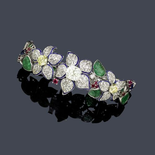 DIAMOND, ENAMEL, EMERALD AND RUBY BRACELET. White gold 750, 57g. Very decorative bracelet, the centre with 3 floral motifs of different sizes, with blue enamelled borders and set with brilliant-cut diamonds, set with 1 old European cut diamond weighing ca. 4.00 ct and 2 fancy-yellow brilliant-cut diamonds weighing ca. 2.00 ct in total, flanked by leaf, bud and flower motifs set with 12 engraved emeralds, 1 round and 5 drop-shaped sapphires weighing ca. 4.10 ct in total, and 28 rubies weighing ca. 2.30 ct in total. Total weight of the 199 brilliant-cut diamonds ca. 3.00 ct. L ca. 19 cm.