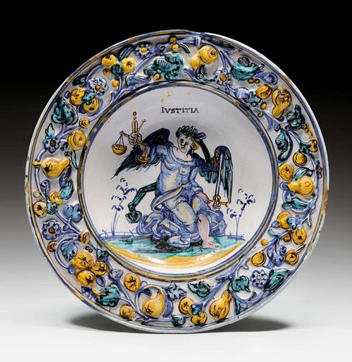 CERAMIC PLATTER 'IUSTITIA',Winterthur, Ludwig II Pfau, ca. 1620-1650. Broad rim with a fruit garland in relief and the Cardinal Virtue of Justitia depicted as a winged, female figure. D 26.5 cm. Chips on the edge.