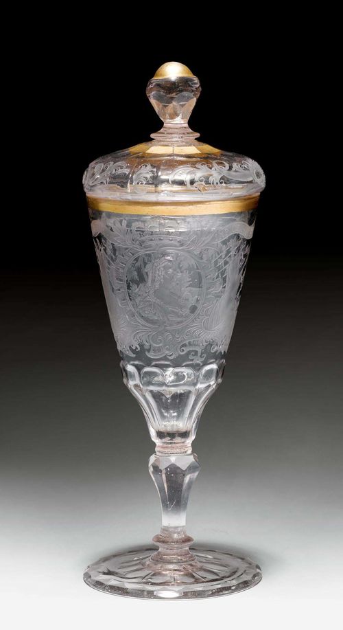 SMALL 'MARIA THERESA' GLASS GOBLET,Bohemia, ca. 1780. Transparent glass. Conical cuppa over a facetted base, diamond-cut baluster shaft. Crowned medallion of the Empress Maria Theresa of Austria flanked by trophies, a landscape scene on the back. Gilt edges. H 20.5 cm. (2) Provenance: Gut Aabach, Risch am Zuger See.