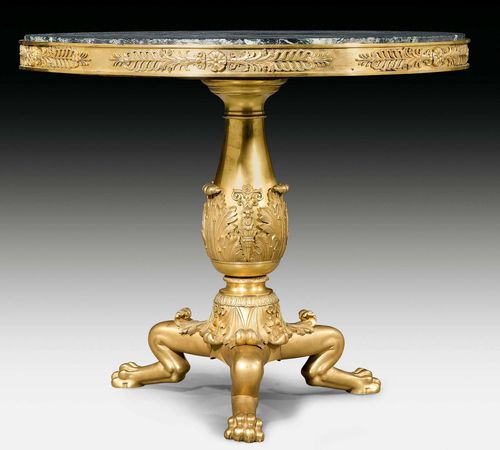ROUND BRONZE GUERIDON "AUX PATTES DE LION",Empire/Restauration, Paris, 19th century. Matte and polished gilt bronze. The gray/beige speckled marble top edged in a bronze ring. Exceptionally fine bronze mounts and applications. D 92 cm. H 80 cm.