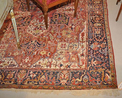HERIZ old.Red ground with cruciform central medallion, patterned in the typical manner, dark blue border, 246x360 cm.