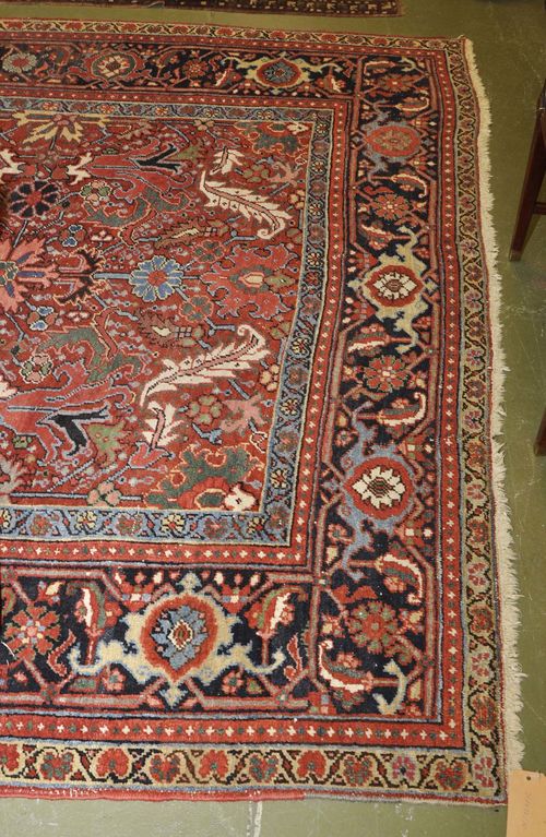 HERIZ antique.Red ground with black border, patterned with stylized plant motifs, traces of wear, 217x300 cm.