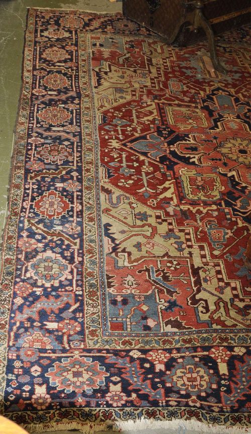 HERIZ antique.Red ground with central medallion, patterned in the typical manner, dark blue border, heavy moth damage, 220x325 cm.