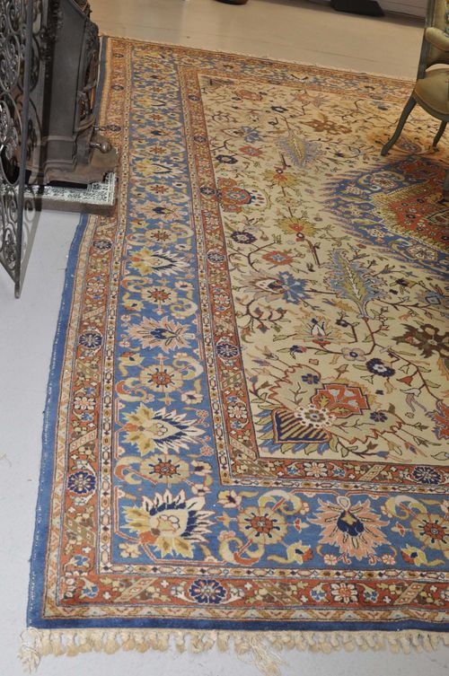 TABRIZ antique.Beige central field with blue central medallion, patterned with flower tendrils and palmettes, blue border, 300x395 cm.