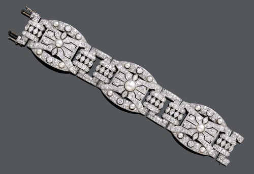 DIAMOND AND PEARL BRACELET, Vienna, ca. 1930. Platinum. Very elegant, geometrically open-worked Art Deco bracelet of 3 large tonneau-shaped links decorated with 5 probably natural pearls of ca. 3.5 to 7.5 mm Ø and set throughout with numerous old European-cut and single-cut diamonds as well as 2 navette-cut diamonds, connected to one another by means of rectangular, intermediate links set with diamonds. Total weight of the ca. 380 diamonds ca. 23.00 ct. Clasp in white gold 585. W ca. 3.2 cm, L ca. 17.5 cm. With case by Chopard.