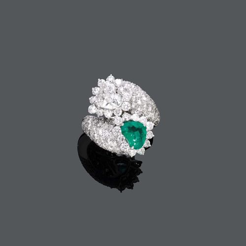 EMERALD AND DIAMOND RING. White gold 750. Elegant cross-over model with 1 heart-shaped diamond weighing 1.62 ct, F/SI1, and 1 heart-shaped emerald weighing ca. 1.20 ct, within a border of diamonds. The ring shoulders pavé-set with numerous brilliant-cut diamonds. Total diamond weight 6.15 ct. Size ca. 56.5. With HRD Certificate No. 10024382003.