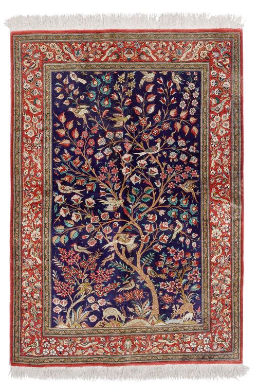 GHOM SILK.Blue ground, patterned with colourful plants and animals, red edging, slight wear, 105x148 cm.