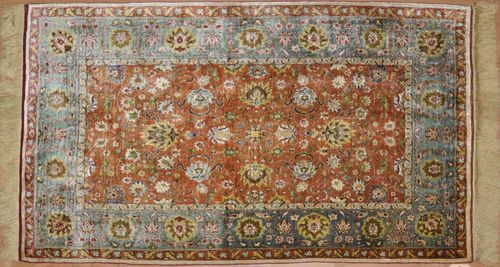 HEREKE old.Central field in dusky pink, finely patterned with blossoms and palmettes, turquoise coloured border with trailing flowers, good condition, 78x115 cm.