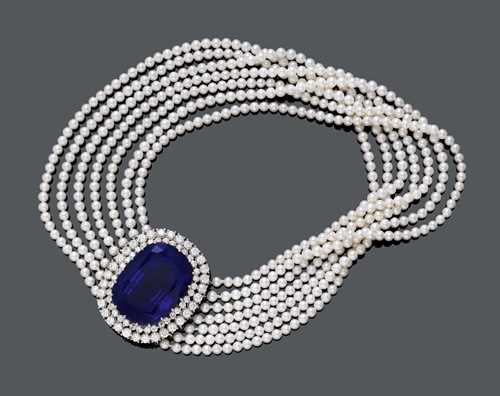 TANZANITE, DIAMOND AND PEARL CHOKER. White gold 750. Very fancy, seven-row necklace of numerous Akoya pearls of 4 mm &#216;, with an elegant clasp in the centre, set with 1 antique-oval tanzanite weighing ca. 136.36 ct, within a double-border of 52 brilliant-cut diamonds weighing ca. 13.20 ct l. L ca. 34.5 cm. With gemstone expert opinion No. 26533 by Walter Mica, Vienna, November 1996.