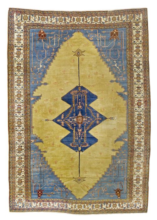 BAKHSHAYESH antique.Blue central medallion on a yellow ground with light corner motifs. The entire carpet is geometrically patterned with stylized human figures, plants and animals. White border with trailing flowers. Expertly restored. 376x560 cm.