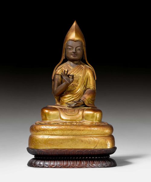 A GILT AND PAINTED REPOUSSE FIGURE OF KHEDRUP JE (1385–1438). Tibet, early 20th c. Height 33 cm (37 cm including the wooden base).  Khedrup je was the abbot of Ganden monastery, the first Panchen Lama and an important follower of Tsongkhapa.