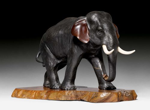 A DARK PATINATED BRONZE FIGURE OF AN ELEPHANT. Japan, Meiji period, length 35 cm. Signed. Wood base.