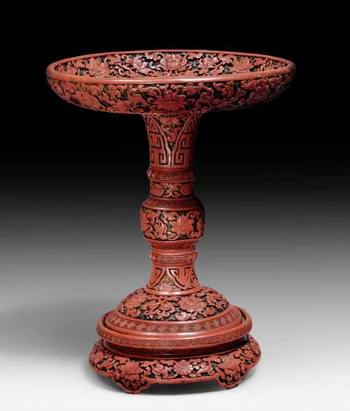 A THREE COLOURED CARVED LACQUER BOWL ON A HIGH STAND.
